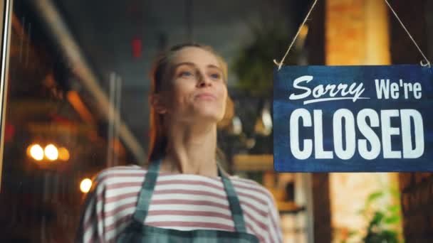 Junge Frau eröffnet Café in der Früh hängen wir sind ein offenes Schild an der Haustür — Stockvideo