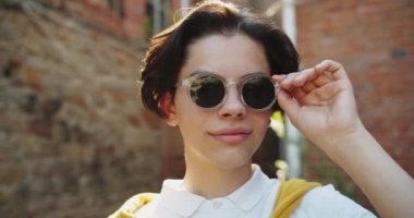 Kameraya bakarak güneş gözlüğü çıkararak yakışıklı genç yakın çekim portre