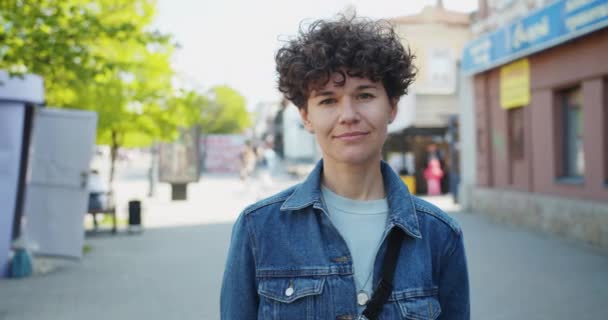 Πορτραίτο της όμορφης νεαρής κυρία φοιτητής χαμογελά στέκεται έξω στο δρόμο — Αρχείο Βίντεο