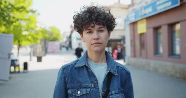 Slow motion portrait of good-looking young woman standing outside in the street — Stock Video