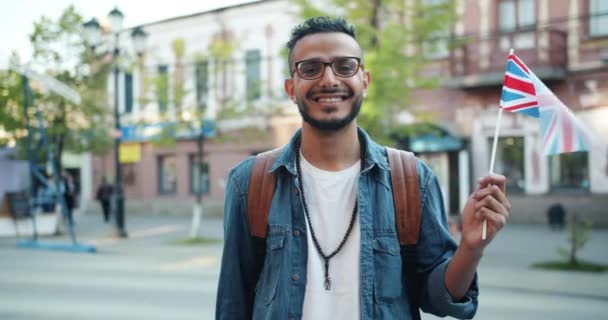 Birleşik Krallık bayrağını tutan neşeli Orta Doğulu adamın yavaş hareketi — Stok video