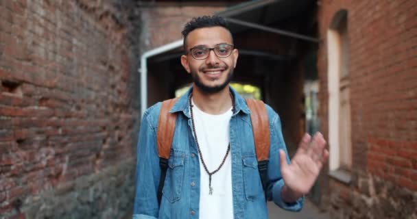 Портрет дружній веселий Арабська людина розмахуючи рукою на відкритому повітрі посміхаючись — стокове відео