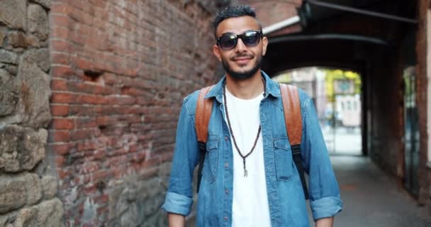 Retrato de un hombre guapo de Oriente Medio quitándose las gafas de sol sonriendo — Vídeos de Stock