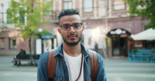 진지한 얼굴로 야외에 서있는 아라비아 남자의 슬로우 모션은 다음 미소 — 비디오