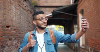 Joyful Afrikalı Amerikalı adam akıllı telefon kamera ile selfie alarak açık havada
