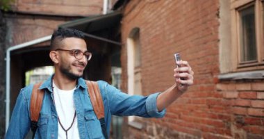 Cheerul Arap adam akıllı telefon açık havada selfie alarak yavaş hareket