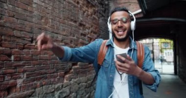 Kulaklık mutlu Arap turist açık havada dans şarkı müzik dinlerken