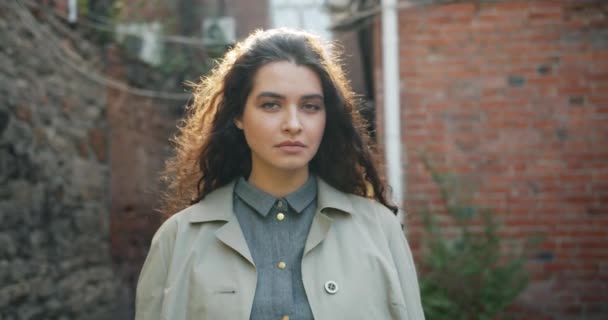 Portrait au ralenti d'une jolie femme aux cheveux longs debout à l'extérieur — Video