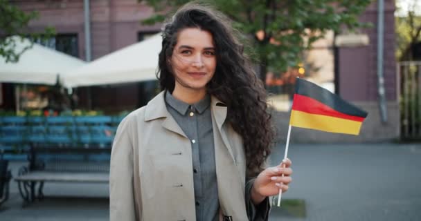 Slow motion portrait of German patriot standing outdoors with flag of Germany — Stock Video