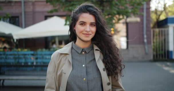 Portrait de jolie jeune femme debout à l'extérieur dans la rue souriant — Video