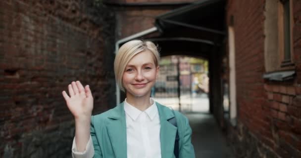 Slow motion portrait of pretty woman waving hand meaning hello outdoors — Stock Video