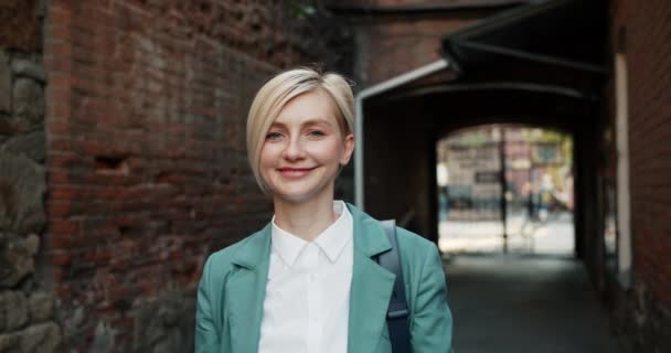 Portrait de jeune femme joyeuse montrant OK geste souriant debout à l'extérieur — Video