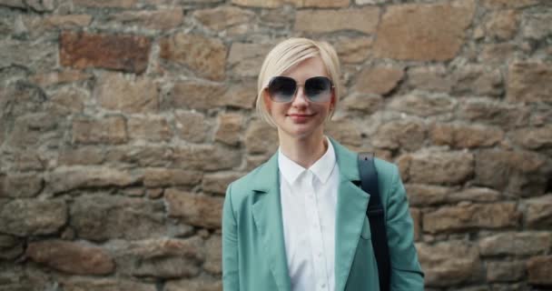 Portrét hezké mladé dámy ve stylových slunečních brýlích a moderních šatech venku — Stock video
