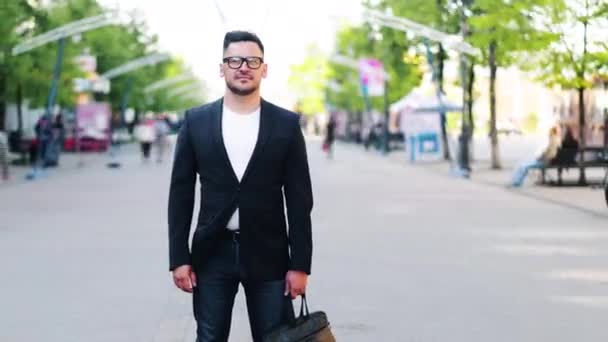 Zoom-out upływ czasu przystojnego faceta z torbą stojącą na zewnątrz na ulicy — Wideo stockowe