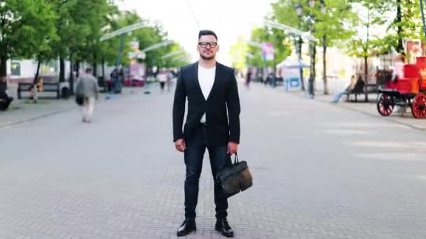 Тайм-ап красивого парня, стоящего на улице в центре города и смотрящего в камеру — стоковое видео