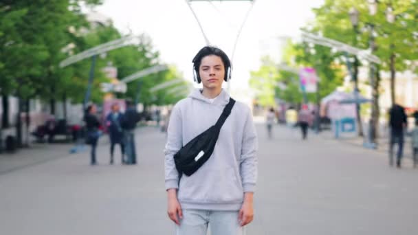Tempo-lapso retrato de adolescente em fones de ouvido em pé ao ar livre na rua — Vídeo de Stock