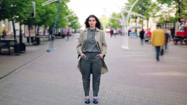 Zeitraffer einer attraktiven jungen Frau, die in der Innenstadt an einer belebten Straße steht — Stockvideo