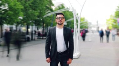 Yaz günü sokakta duran gözlüklü ciddi adamın hızlandırılmış portresi