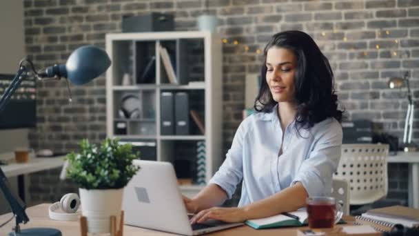 Portrait de jeune femme séduisante tapant dans le bureau en regardant la caméra sourire — Video