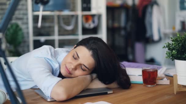 Mujer joven agotada durmiendo en el ordenador portátil en el trabajo descansando después del día de trabajo duro — Vídeos de Stock