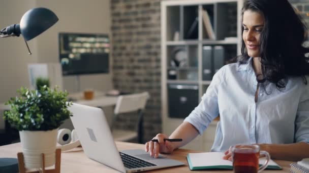 Flicka upptagen med laptop i Office surfar tittar på skärmen sitter vid skrivbordet — Stockvideo