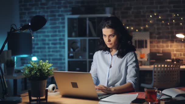 Donna d'affari che lascia il posto di lavoro a tarda notte spegnendo luce e laptop — Video Stock