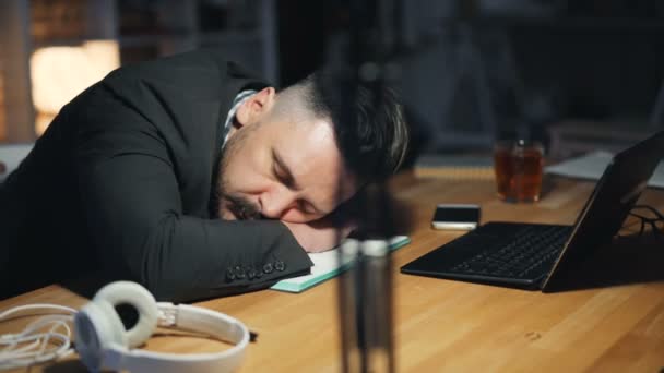 Портрет уставшего красавца, спящего на столе в темном офисе поздно ночью — стоковое видео