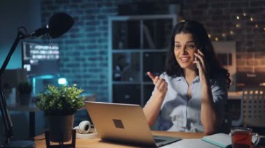 Kızgın genç bayan gece ofiste sorunları tartışıyor cep telefonu yla konuşuyor