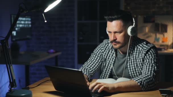 Aantrekkelijke man afwerking werk in Office uitschakelen laptop en lamp 's nachts — Stockvideo