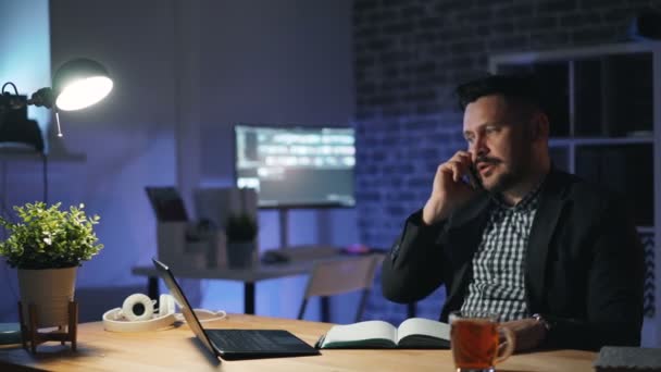 Stressad entreprenör pratar på mobiltelefon på natten i kontoret arbetar sent — Stockvideo