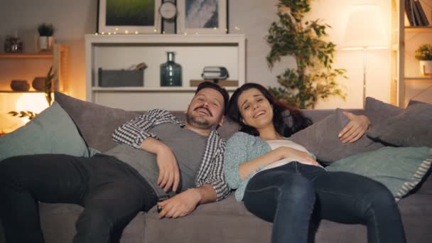 Neşeli çift evde konuşurken eğlenerek geceleri tv izlerken gülüyor — Stok video