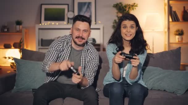 Linda pareja marido y mujer jugando videojuegos en casa, hombre alegre ganar — Vídeo de stock