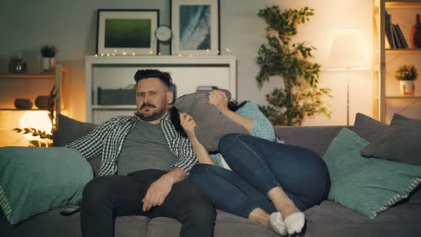 Man And Woman Watching Shocking News On Tv At Home Guy Comforting
