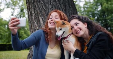 Akıllı telefon kamerakullanarak parkta köpek yavrusu ile selfie çeken öğrencilerin yavaş çekim