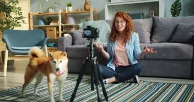 Neşeli blogger köpek sahibi nin yavaş hareket modern kamera kullanarak video kayıt