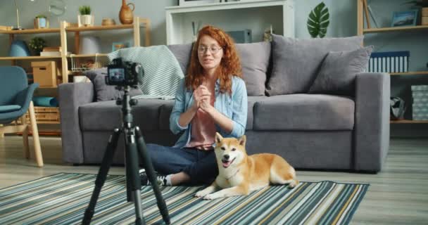 Cámara lenta de la chica feliz vlogger grabación de vídeo con perro adorable en casa — Vídeo de stock