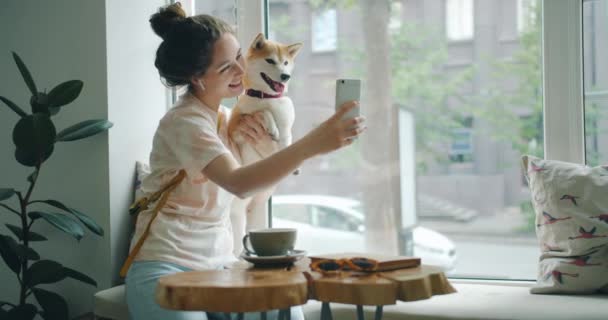 Felice signora prendendo silfie con cane utilizzando smartphone divertirsi in caffè — Video Stock