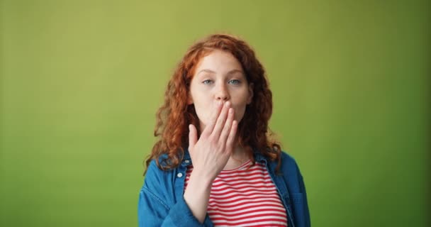 Portret van tiener meisje verzenden lucht kus en winking op groene achtergrond — Stockvideo