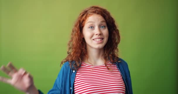 Porträt einer fröhlichen Studentin, die eine freundliche Geste zeigt und lächelnd in die Kamera schaut — Stockvideo