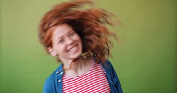 Aantrekkelijke tiener meisje Moving Head zwaaiende krullend haar op groene achtergrond — Stockvideo