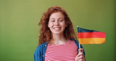 Almanya'nın ulusal bayrağını tutan büyüleyici Alman genç kız gülümseyerek