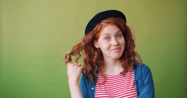 Sevimli genç kız portre parmak gülümseyerek flört etrafında saç sarma — Stok video