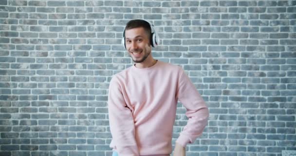 Retrato del hombre barbudo escuchando música en auriculares y bailando — Vídeos de Stock