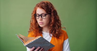 Yeşil arka plan üzerinde kitap okuma gözlük güzel kız Portresi