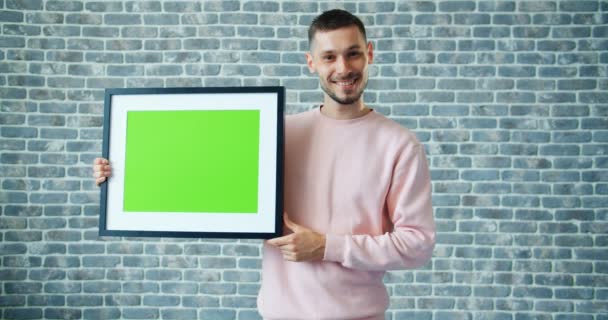 Portret van knappe man met chroma key Picture frame en het tonen van duimen-up — Stockvideo