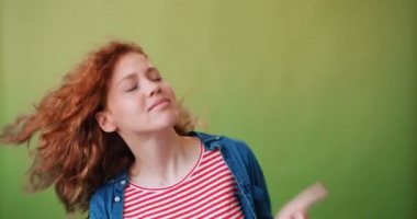 Neşeli kızıl saçlı kız dans ve yeşil arka plan üzerinde gülümseyen Portresi