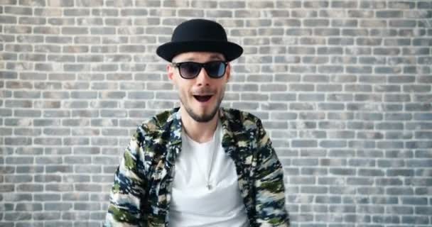 Slow motion unga hipster dansa på tegel bakgrund när pengar faller — Stockvideo