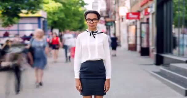 Time lapse di razza mista ragazza in piedi in strada pedonale con viso serio — Video Stock