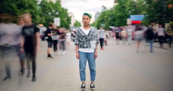 Временной промежуток азиатского подростка-хипстера, стоящего в центре города на оживленной улице — стоковое видео