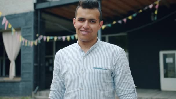 Portrait of cheerful mixed race man standing outdoors alone smiling — Stock Video